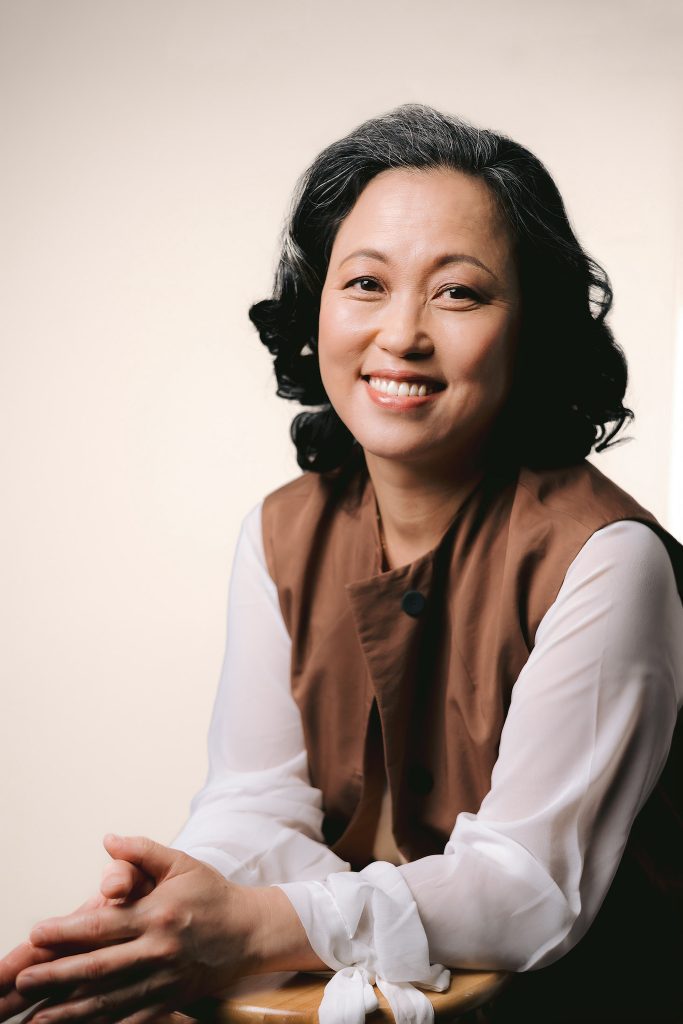 a businesswoman with dark hair and a brown shirt, captured in a professional branding session, highlighting her empathy and confidence.