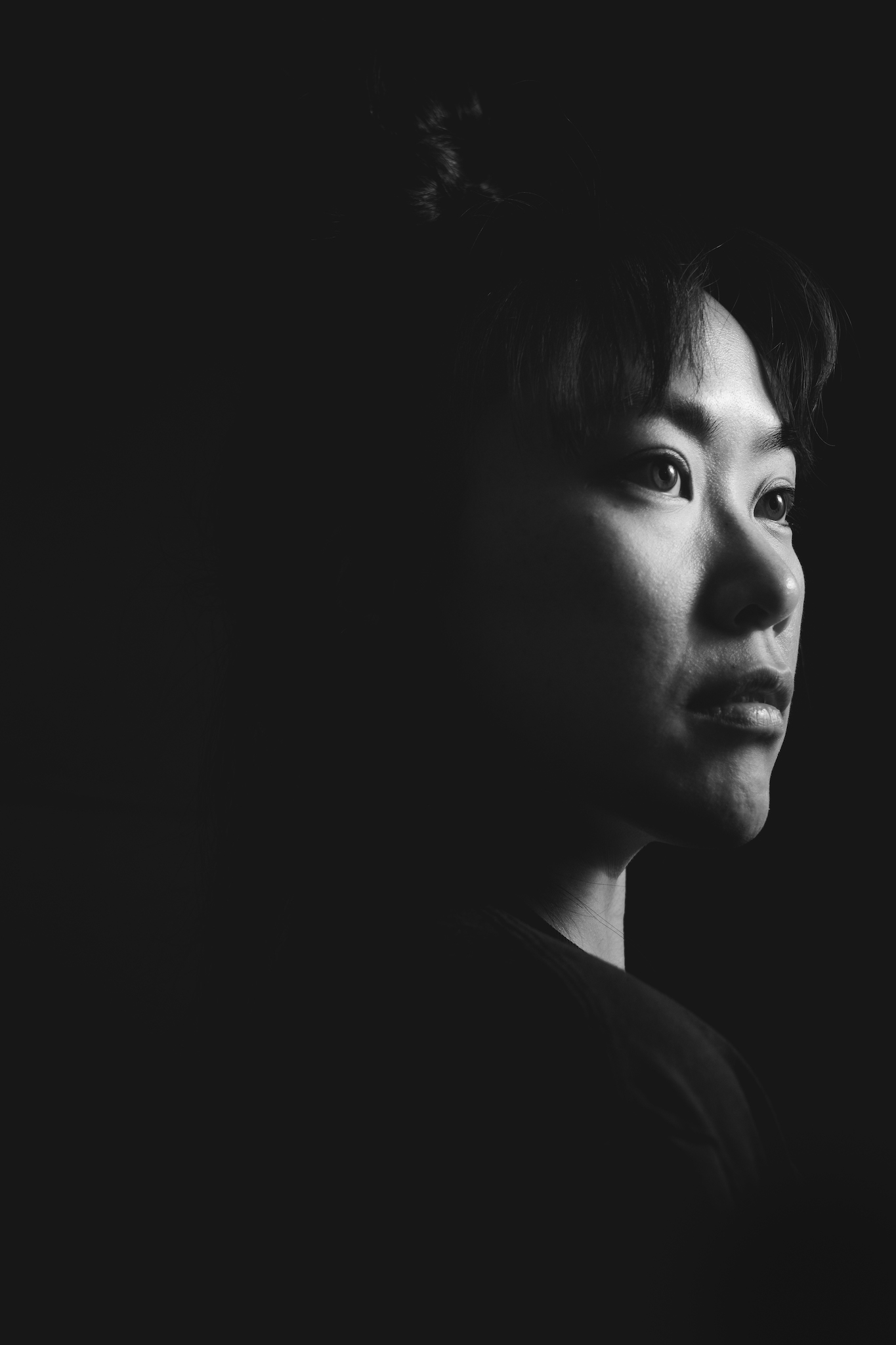 A profile side self-portrait of a photographer with dramatic lighting effects in black and white.